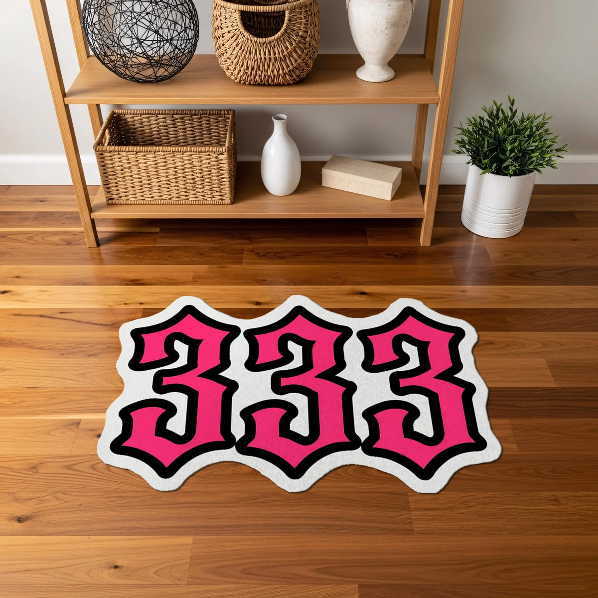 Kalın ve kıvrımlı yazı karakteriyle oluşturulmuş “333” tipografisi içeren, pembe, beyaz ve siyah renk kombinasyonuna sahip, yüksek kontrastlı, pop kültür ve graffiti stilini yansıtan figürlü halı yüzeyi.
