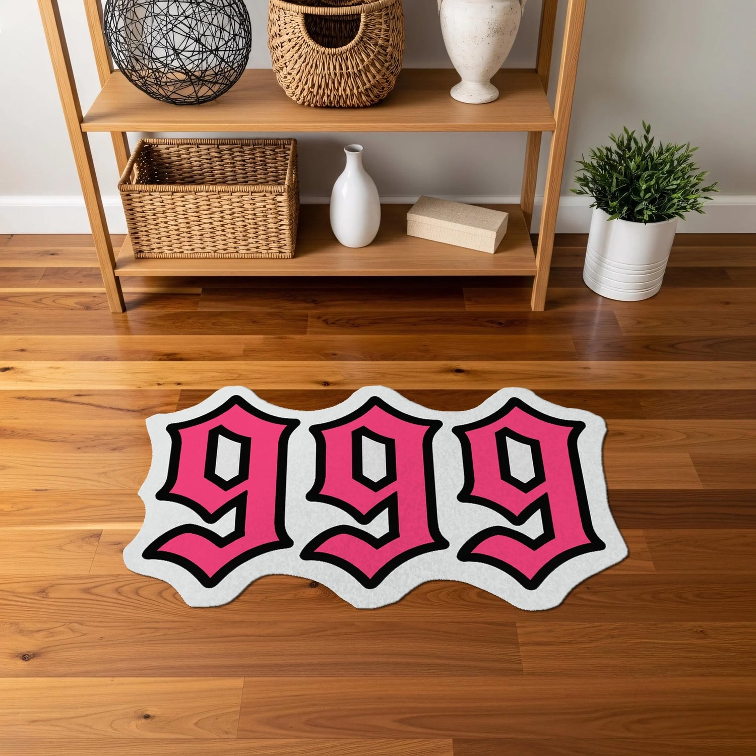 Yan yana dizilmiş “999” rakam kompozisyonu şeklinde, parlak pembe dolgu rengi, belirgin beyaz ara kontur ve güçlü siyah çerçeveyle vurgulanan, sokak sanatı estetiğinde, modern tipografi temalı, özel formlu dekoratif halı tasarımı.
