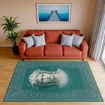 Merkez alanında antik heykel stilinde kadın yüzü illüstrasyonu yer alan turkuaz tonlu dekoratif halı; mermer heykel dokusunu andıran çizgisel detaylar, zarif bitkisel bordürler ve dengeli yüzey yerleşimiyle klasik sanat teması.