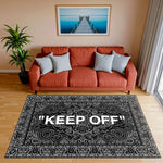 Merkezde büyük beyaz yazı bulunan, çevresi detaylı oriental paisley motifleriyle kaplı siyah zeminli halı; tipografik vurgu, klasik desen dokusu ve modern sokak sanatı estetiğini birleştiren güçlü görsel kompozisyon.
