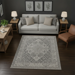 Açık gri ve koyu gri tonlarında, merkezde geometrik madalyon ve çevresinde simetrik etnik motifler bulunan modern–klasik stil halı; ince çizgili bordür çerçevesi, dengeli desen yoğunluğu, minimal renk paleti ve dokuma görünümlü yüzey dokusu.
