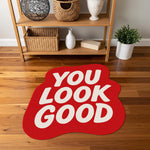 Pozitif mesaj içeren “YOU LOOK GOOD” yazılı halı; beyaz büyük harfler, akışkan organik kenar formu, düz kırmızı zemin ve pop kültür estetiğini yansıtan minimal tipografi kompozisyonu ile tasarlanmış çağdaş stil baskı.
