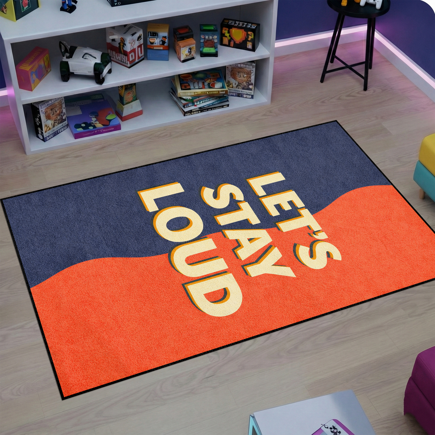 Pop art ve modern grafik estetiğinde tasarlanmış dekoratif halı, koyu mavi zemin üzerinde merkezde büyük ve kalın tipografi ile yazılmış “LET’S STAY LOUD” metni içerir. Turuncu dalga formunda renk bloğu yazının arkasında güçlü kontrast oluşturur ve minimal tipografi odaklı grafik tasarım kompozisyonu sunar.