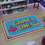 Retro oyun temalı dekoratif halı, merkezde GAME ON! yazısı ile dikkat çeker. Piksel stil joystick ve grid zemin detayları ile nostaljik ve enerjik bir tasarım sunar.