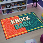 Eğlenceli ve dikkat çekici tasarıma sahip halı, merkezde KNOCK BABY yazısı barındırır. Turuncu ve yeşil renk blokları ile modern ve dinamik bir atmosfer oluşturur.