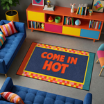 Pop art ve retro grafik estetiğini yansıtan dekoratif halı tasarımı, merkezde büyük ve kabartma etkili turuncu tipografi ile yazılmış “COME IN HOT” metnini barındırır. Koyu mavi zemin güçlü kontrast oluştururken çevresinde sarı çerçeve ve turuncu sarı tonlardan oluşan geometrik kare desenli bordür yer alır.