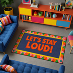 Modern ve renkli tasarıma sahip dekoratif halı, merkezde LET’S STAY LOUD! yazısı ile dikkat çeker. Geometrik çerçeve ve canlı renk blokları ile enerjik ve eğlenceli bir görünüm sunar.