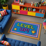 Grafik ve retro oyun tarzında hazırlanmış dekoratif halı, merkezde LEVEL UP yazısı barındırır. Mavi zemin üzerinde piksel efektler ve parlak renkler ile güçlü bir kompozisyon oluşturur.