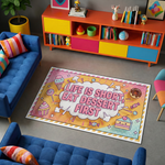Grafik illüstrasyon tarzında hazırlanmış pop art temalı dekoratif halı, merkezde büyük tipografik metin kompozisyonu içerir. “LIFE IS SHORT EAT DESSERT FIRST” yazısı bulut formu içinde yer alırken çevresinde dondurma külahı, cupcake, donut, şeker ve pasta gibi tatlı figürleri bulunan renkli illüstratif tasarım bulunur.